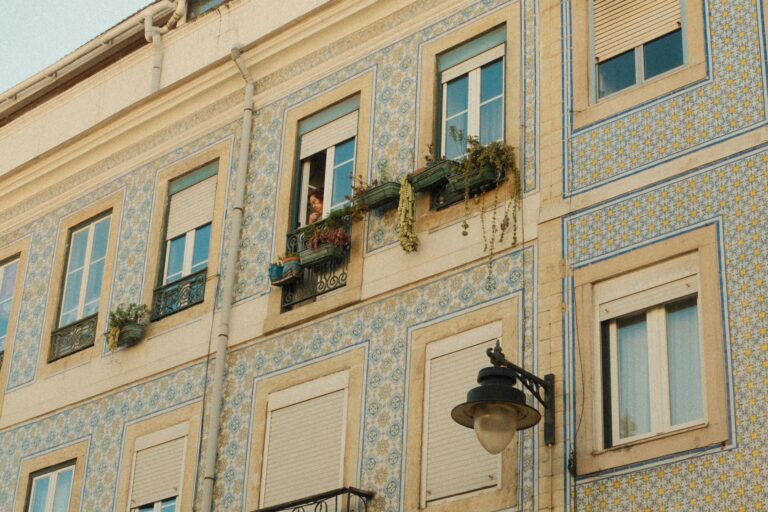 Historyczna fasada w Lizbonie z płytkami azulejos i osobą w oknie